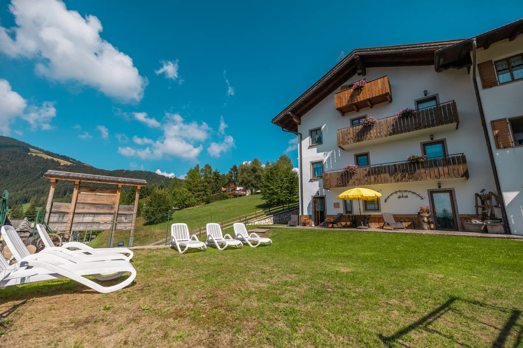 La casa del B&B Wanderlust a Folgaria, con il prato e le sdraio