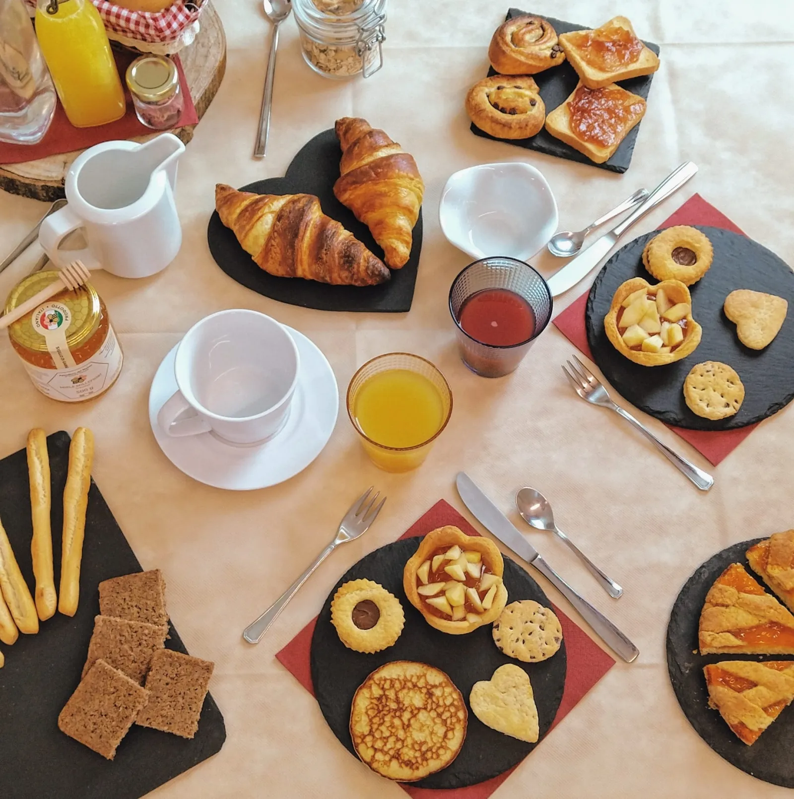 Croissant, biscotti, crostata e miele sul tavolo della colazione