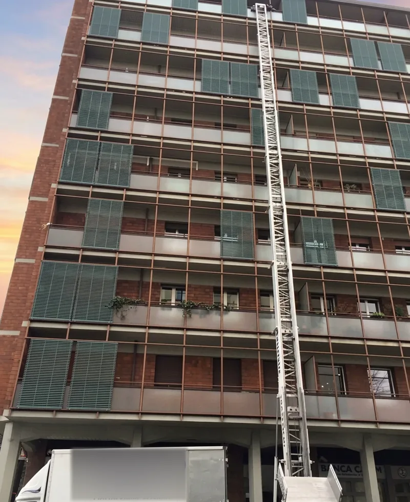 Scala montacarichi Franzini lungo la facciata di un palazzo alto, con il furgone sotto