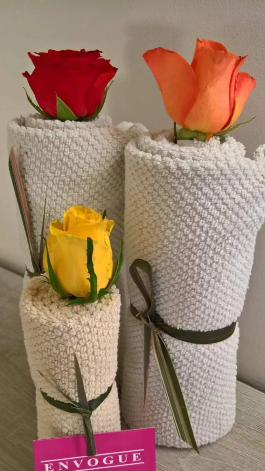 Gli asciugamani arrotolati con le rose